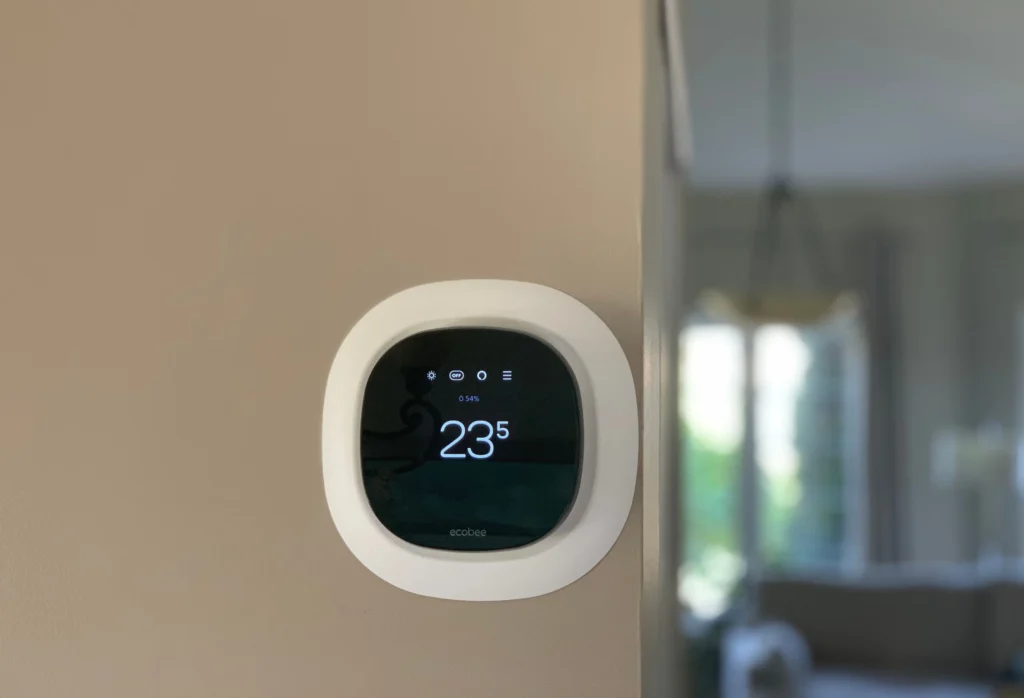 Wall-mounted smart thermostat installed for precise temperature control, improving energy efficiency and indoor comfort in a modern home