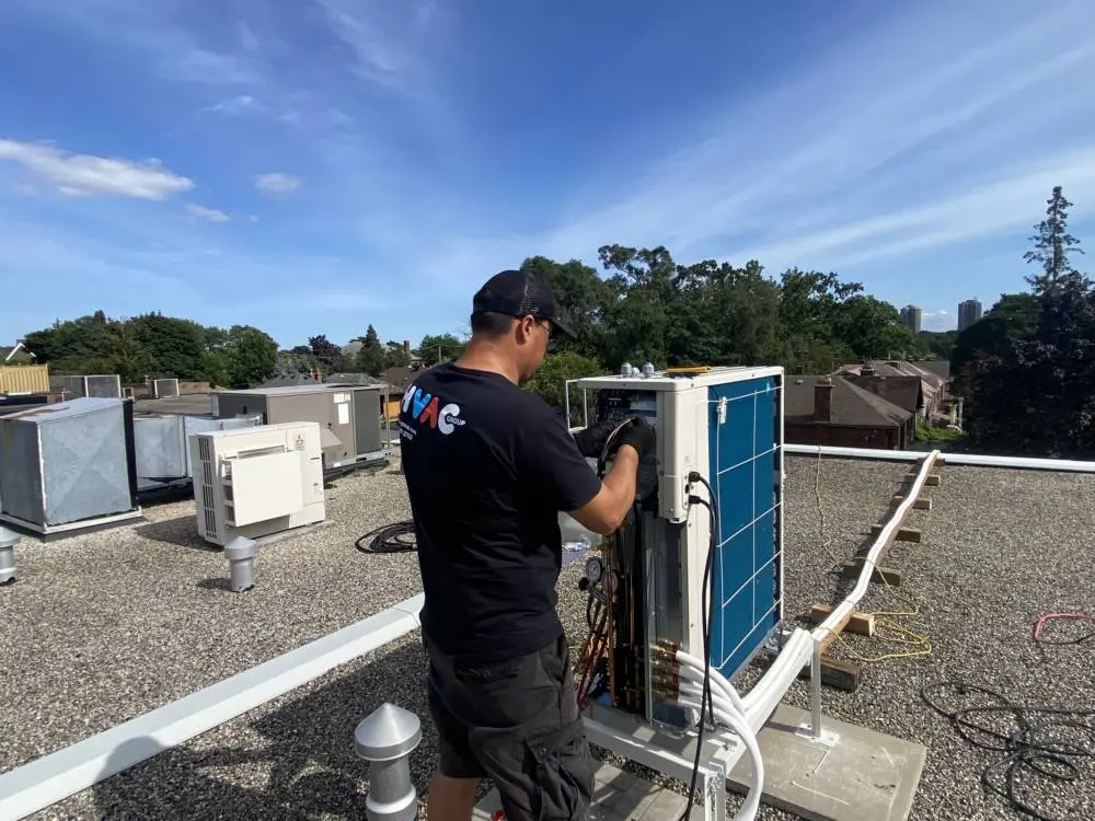 HVAC technician installing a heat pump system on a commercial rooftop for efficient heating and cooling