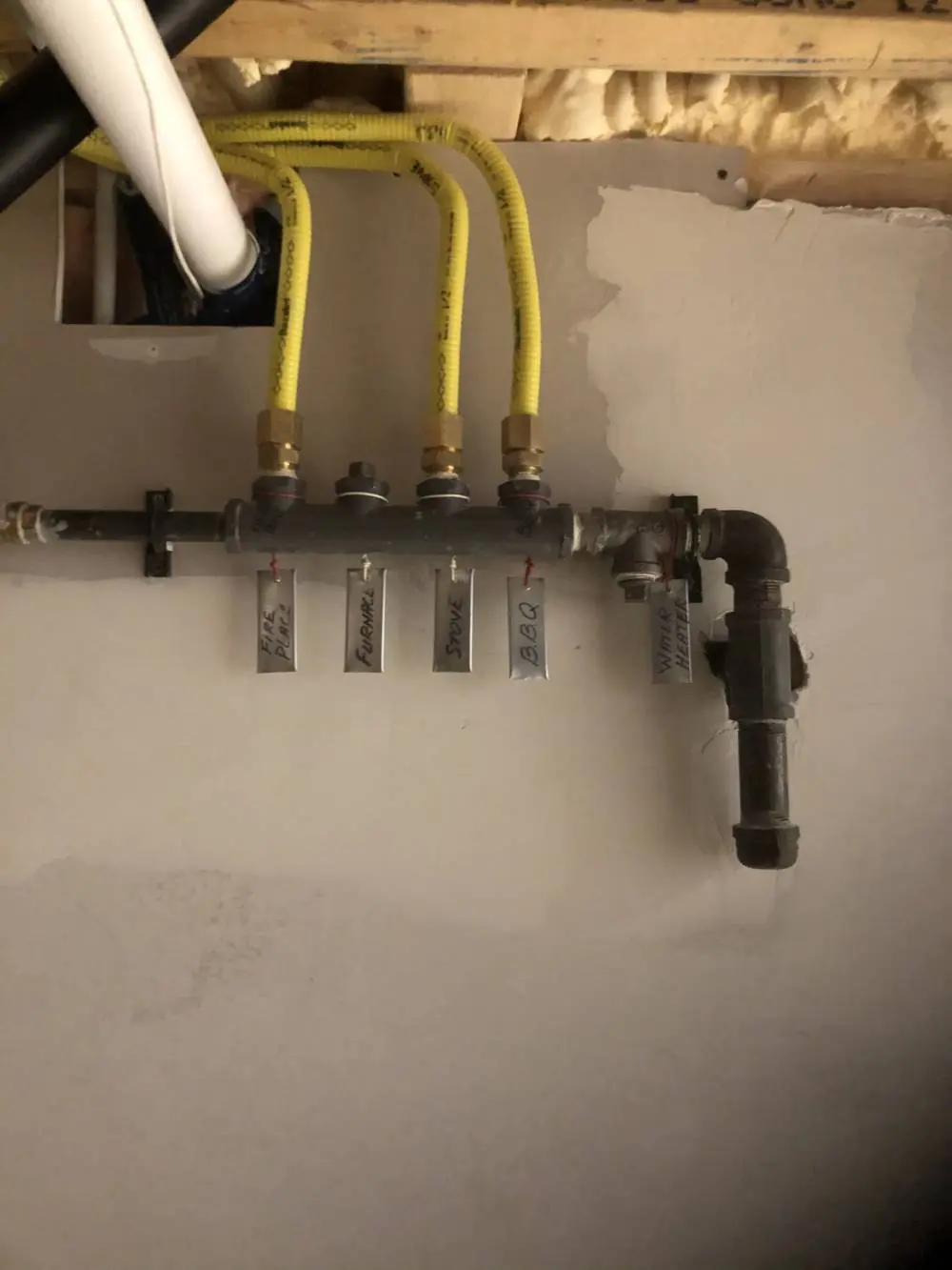 Labeled gas manifold system installed by HVAC Group in the GTA, showing yellow CSST lines running to BBQ, stove, fireplace, furnace, and water heater