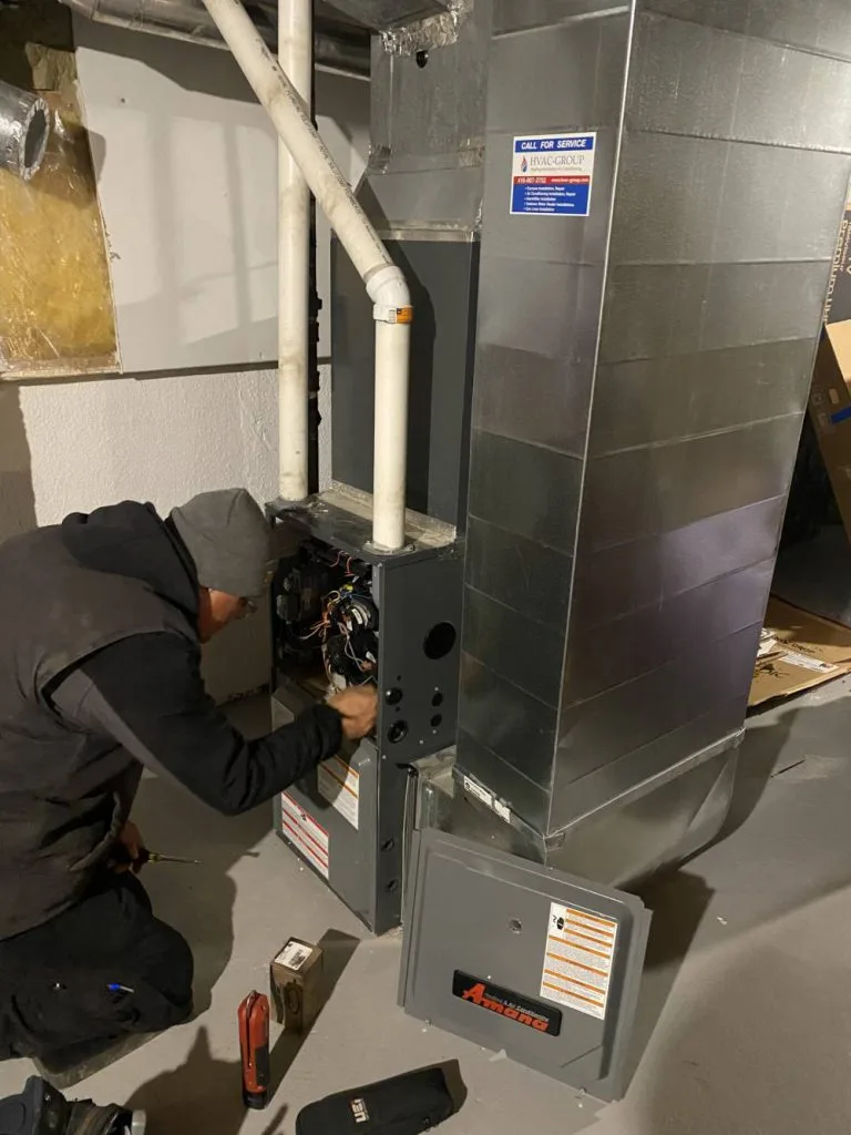 HVAC Group technician repairing an Amana gas furnace in a Mississauga basement utility room