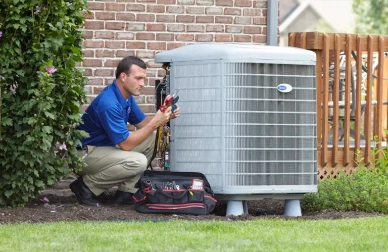 HVAC Technician Servicing a Carrier Air Conditioner Condenser Unit at a Residential Property