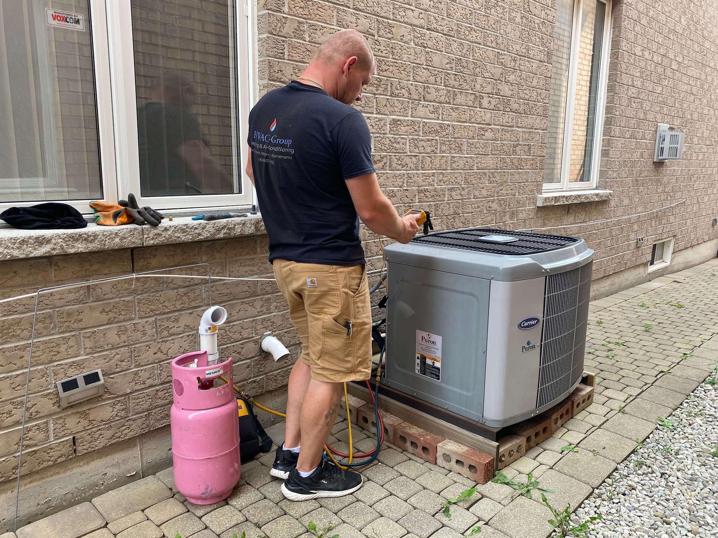 HVAC Group Technician Servicing a Carrier Air Conditioner in Mississauga